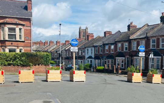 A residential road with large planters placed to block car access